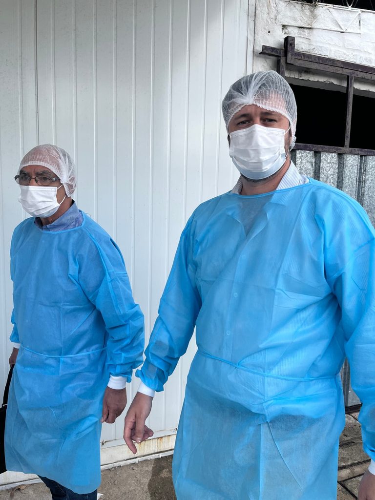 Dos integrantes del equipo con indumentaria sanitaria durante una visita técnica a una planta en Uruguay