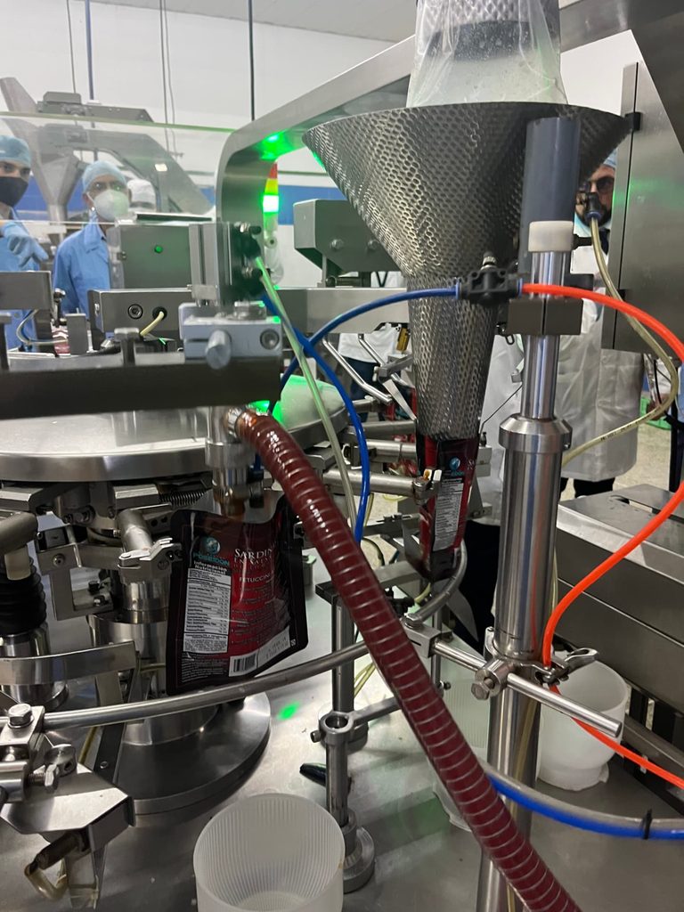 Línea de envasado automatizada llenando empaques de alimentos en una planta industrial
