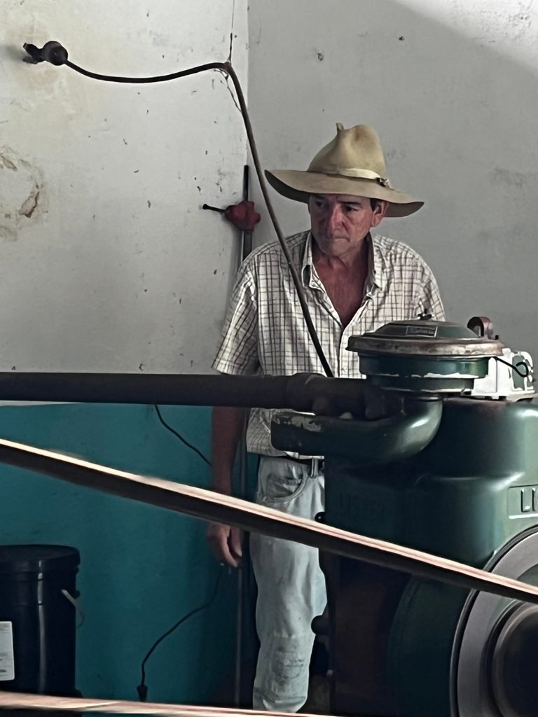Productor operando una máquina trilladora de café en un beneficio tradicional