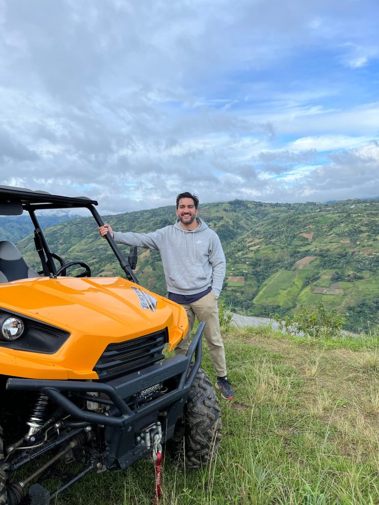 Integrante del equipo junto a un vehículo todoterreno en un mirador de montaña andina